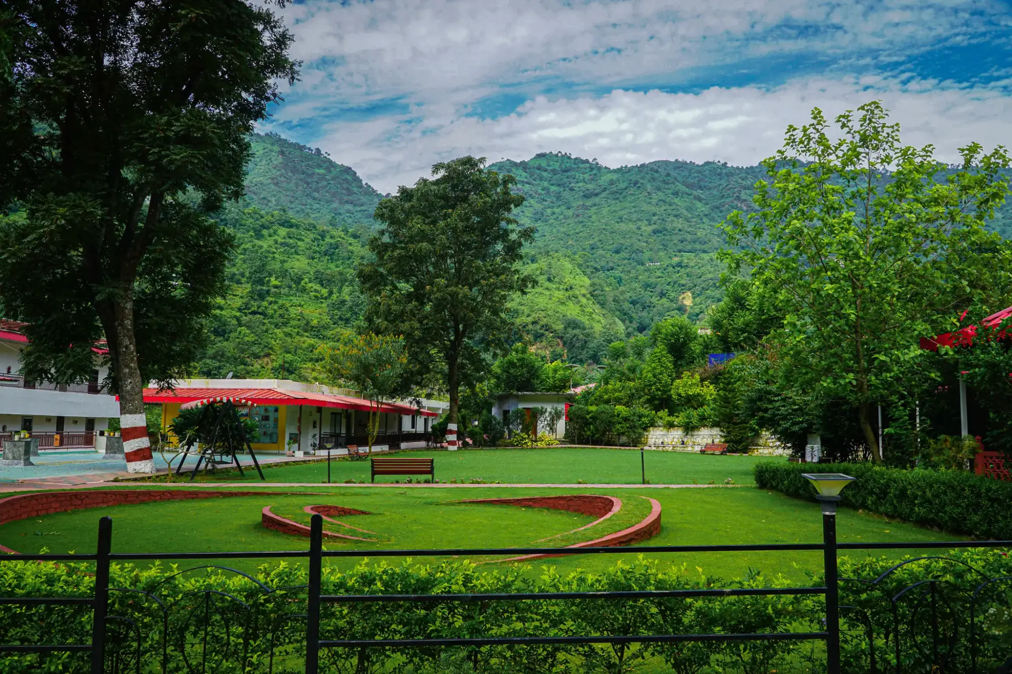 The ashram lawns and buildings beneath forested Himalayan hills